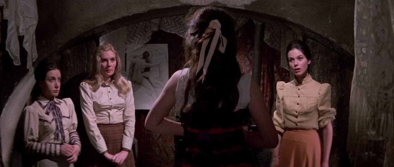 The House That Screamed (1969) movie still: medium — A dimly lit attic space features low arched beams and draped fabrics on walls. Four young women…
