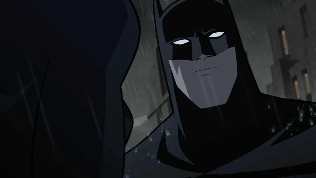 Batman: The Long Halloween, Part One (2021) movie still: medium — A dark urban environment with heavy rain falling against high-rise city…