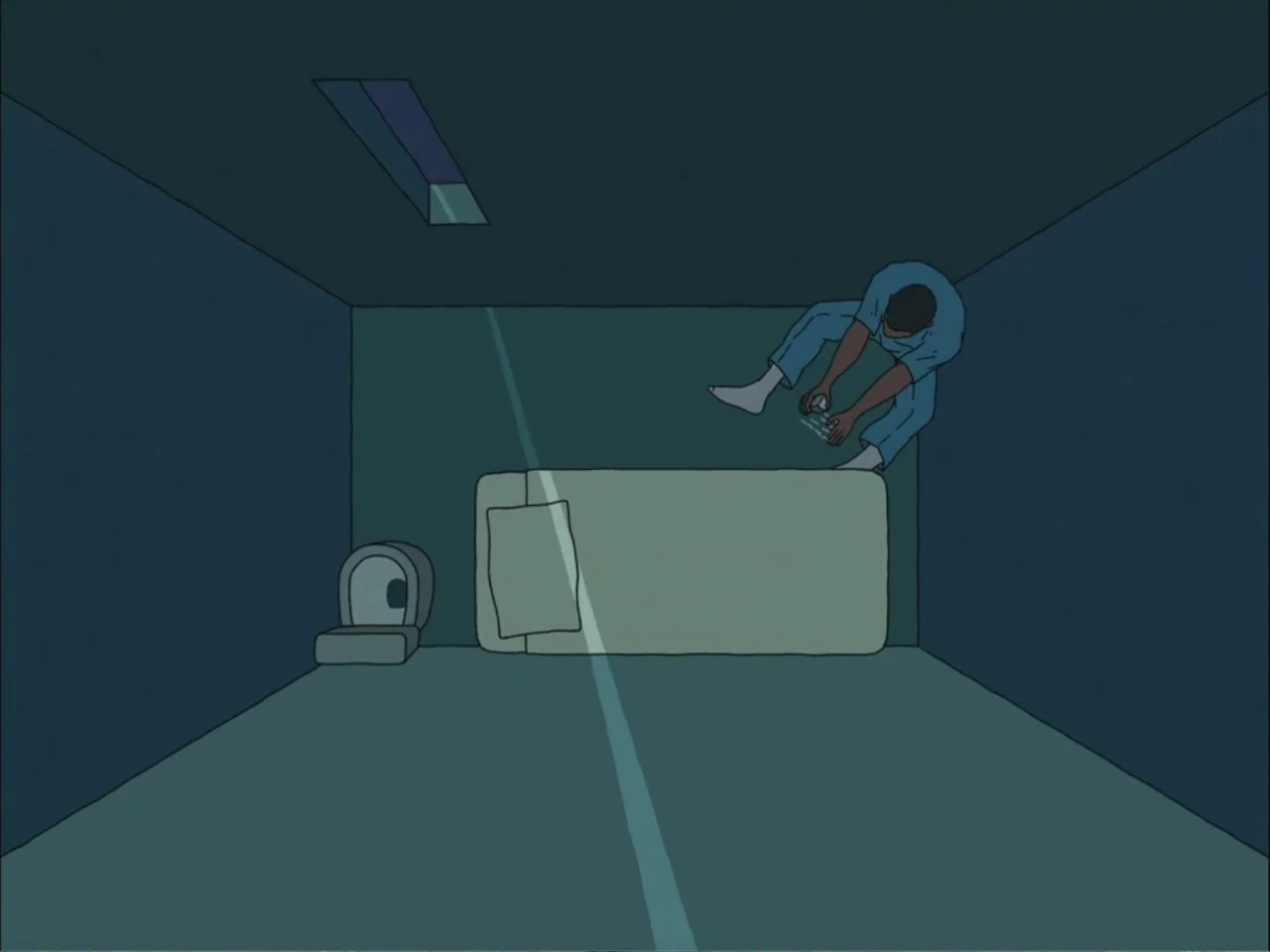 As We Speak: Rap Music on Trial (2024) movie still: wide — A spartan room features a flat cot and a small commode against a wall. A man sits alone…
