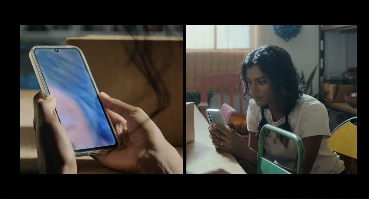 Picture This (2008) movie still: medium — A split-screen view shows a close-up of a phone and a woman at a desk. The woman wears a white t-shirt…