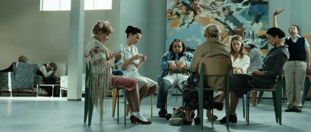 Adam Resurrected (2008) movie still: wide — A spacious, sterile room features a large abstract painting on a plain light wall. A small group of…