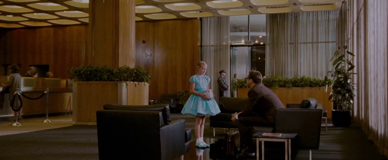 A Single Man (2009) movie still: wide — A mid-century modern lobby features wood-paneled walls, leather chairs, and a grid-patterned coffered…