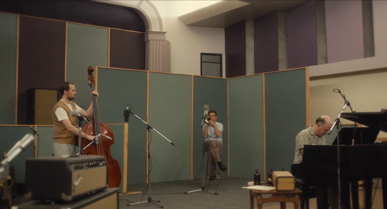 Born To Be Blue (2015) movie still: wide — A 1950s sound recording studio features soundproof acoustic panels on the walls. Three musicians play a…