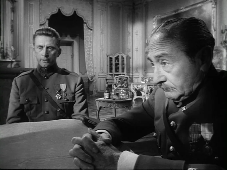 Paths of Glory (1957) movie still: medium — A formal chateau interior features ornate wall paneling and a small table with decanters. Two military…