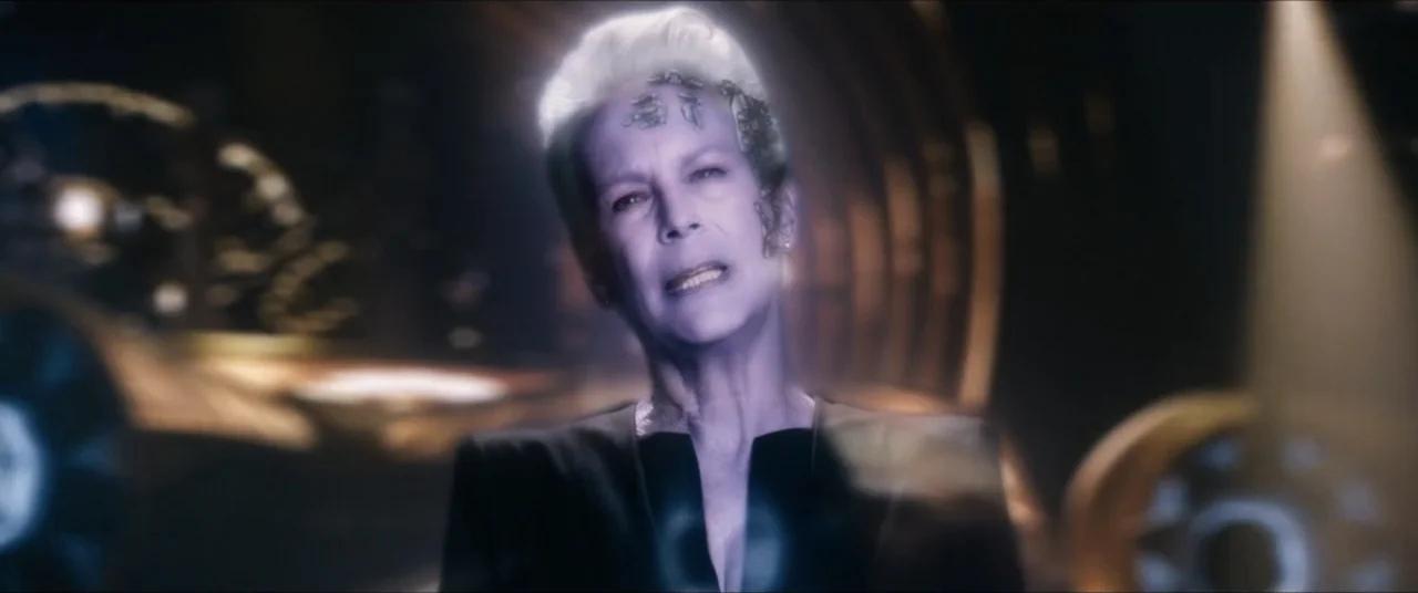 Star Trek: Section 31 (2025) movie still: medium — A dark, blurred futuristic interior with warm gold light accents in the background. A woman with…