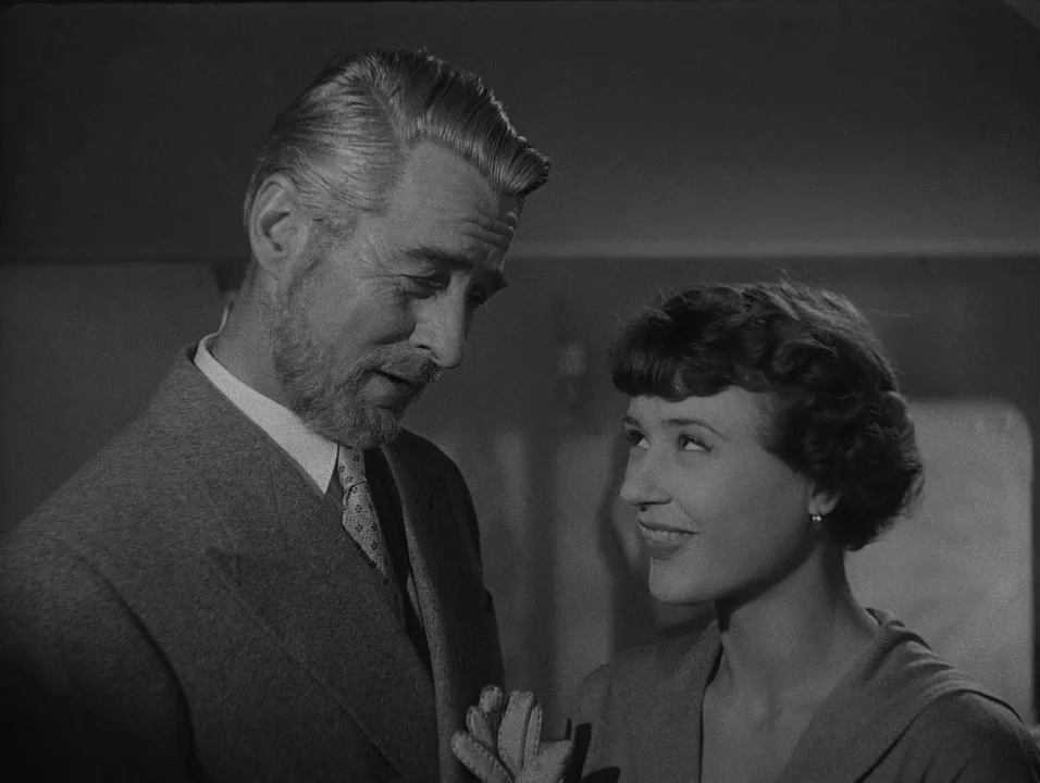 Dreams (1955) movie still: medium — The interior of a 1940s train cabin features dimly lit walls and soft surfaces. An older man in a suit looks…