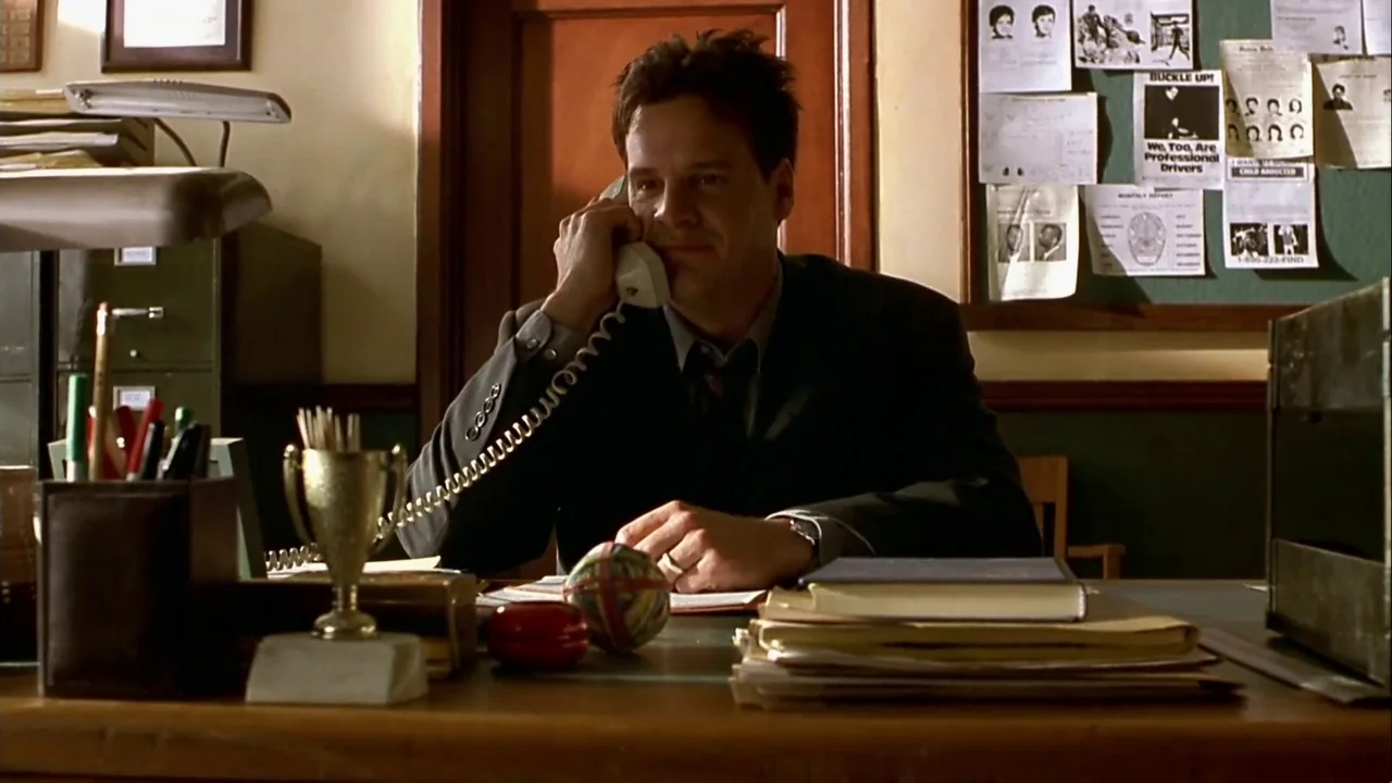 Hellraiser: Inferno (2000) movie still: medium — A workspace with a wooden desk holding papers, a trophy, and a telephone. A man wearing a suit…