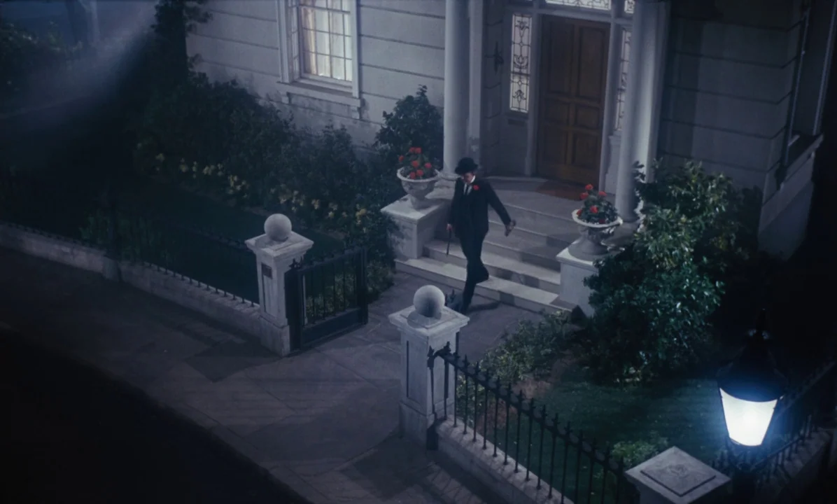 Mary Poppins (1964) movie still: wide — A grand white house with a columned entryway features a small front garden. A man in a dark suit walks down…