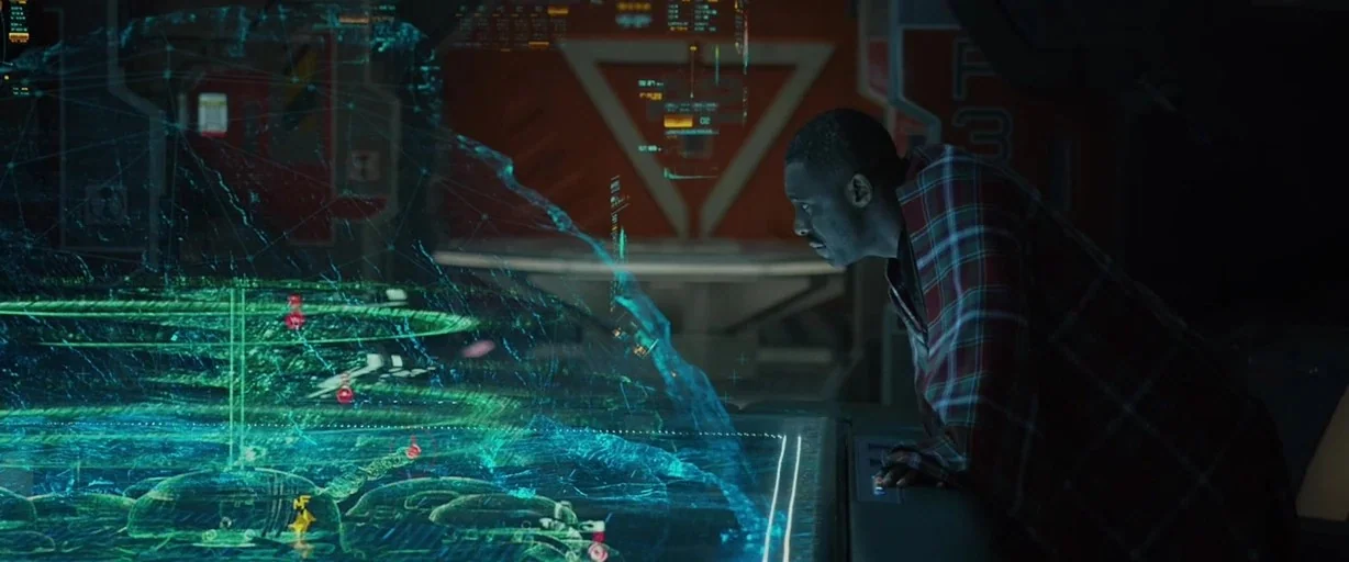 Prometheus (2012) movie still: medium — A dark, industrial spaceship interior features a large glowing holographic table displaying complex data. A…