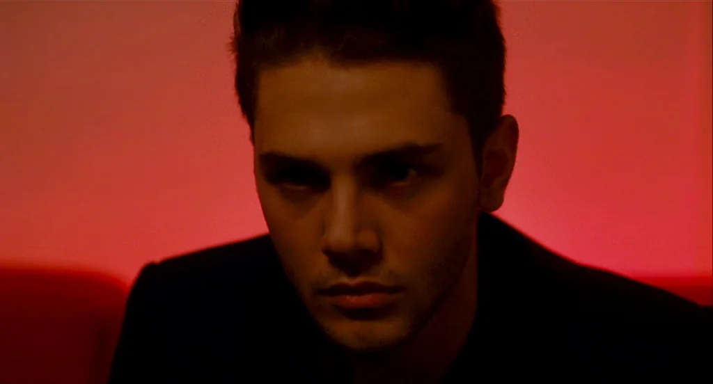 Heartbeats (Les Amours Imaginaires) (2010) movie still: closeup — A man stands in an undifferentiated space filled with intense monochromatic red…