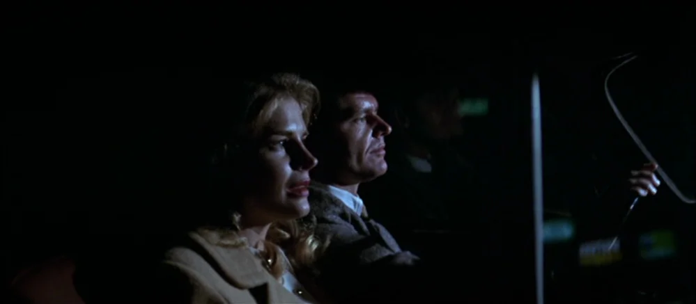 Carnal Knowledge (1971) movie still: medium — A man and a woman sit inside a dark vehicle at night. The interior is dimly lit, focusing on the two…