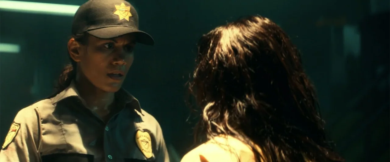 Bad Boys for Life (2020) movie still: medium — A dark, dimly lit security room features a female officer facing an unidentified woman. The officer…