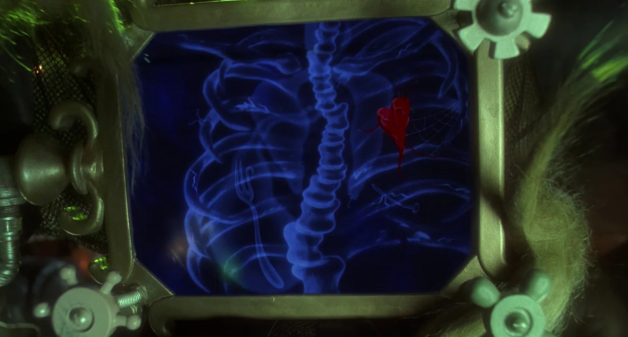 How The Grinch Stole Christmas (2000) movie still: closeup — A glowing blue medical X-ray of a ribcage sits inside a metallic framed device. A…