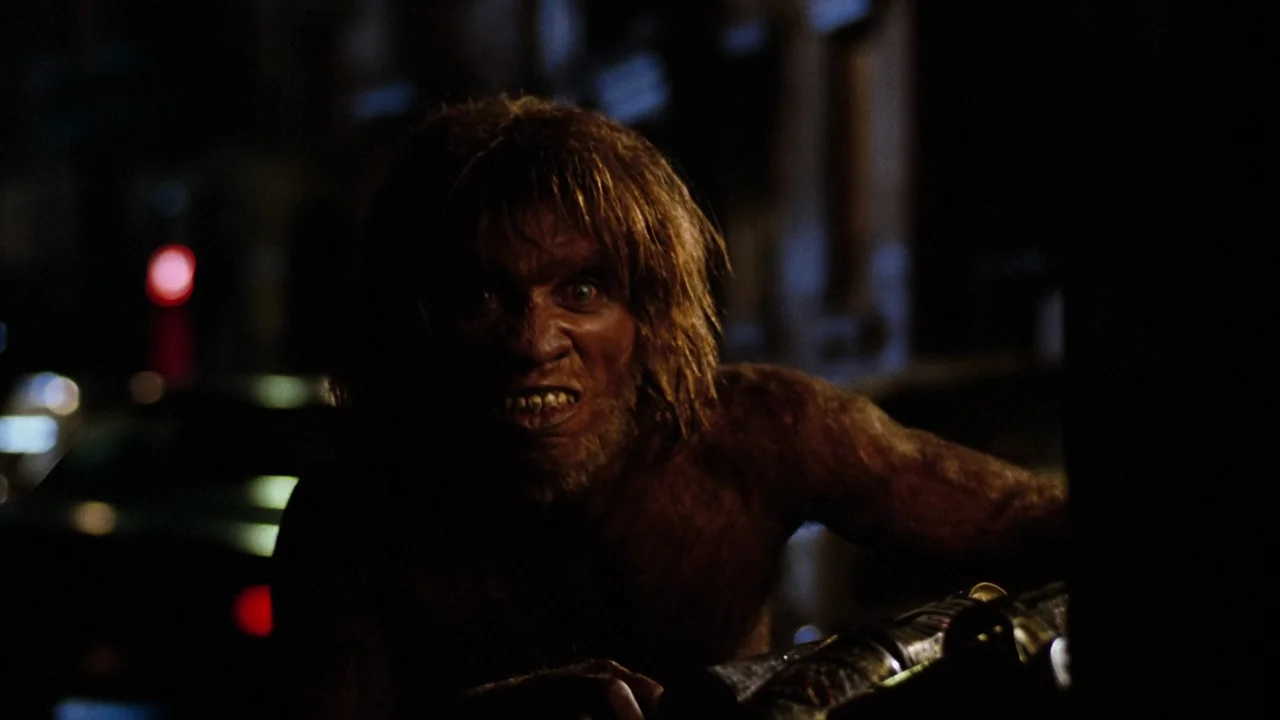 Altered States (1980) movie still: closeup — A dark, blurred urban street at night provides a shallow background for the subject. A shirtless,…