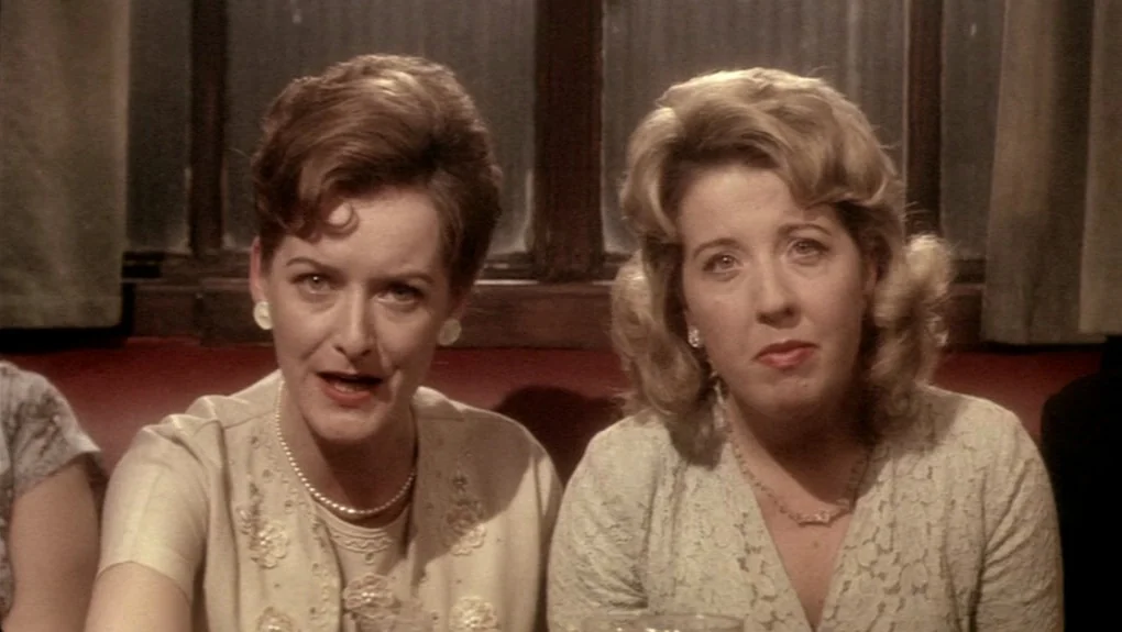 Distant Voices, Still Lives (1988) movie still: medium — Two middle-aged women sit together in a dimly lit diner booth at night. They are both…