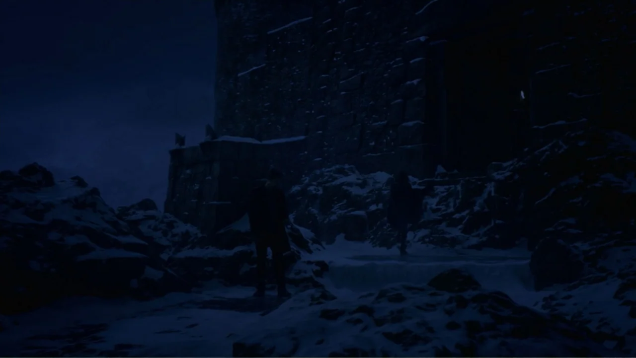 Underworld: Blood Wars (2016) movie still: wide — A massive dark stone fortress wall sits nestled against a rugged, snow-covered mountain slope. Two…