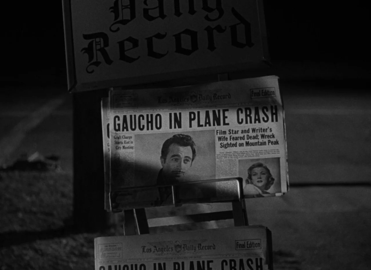 The Bad and the Beautiful (1952) movie still: closeup — A metal newspaper rack displays the Los Angeles Daily Record on a dark street. The headline…