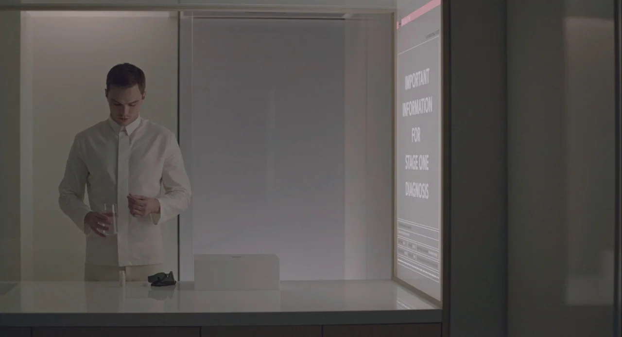 Equals (2015) movie still: medium — A minimalist, sterile medical environment features clean white surfaces and sharp architectural lines. A young…