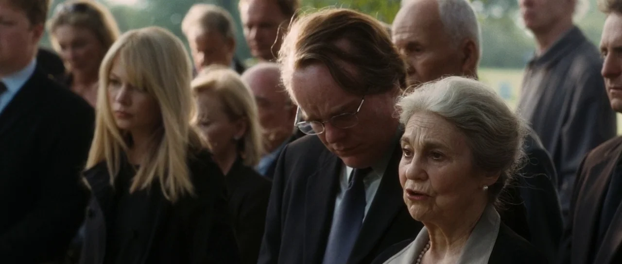 Synecdoche, New York (2008) movie still: medium — An outdoor group of people in formal attire gather at a burial site. A middle-aged man and an…