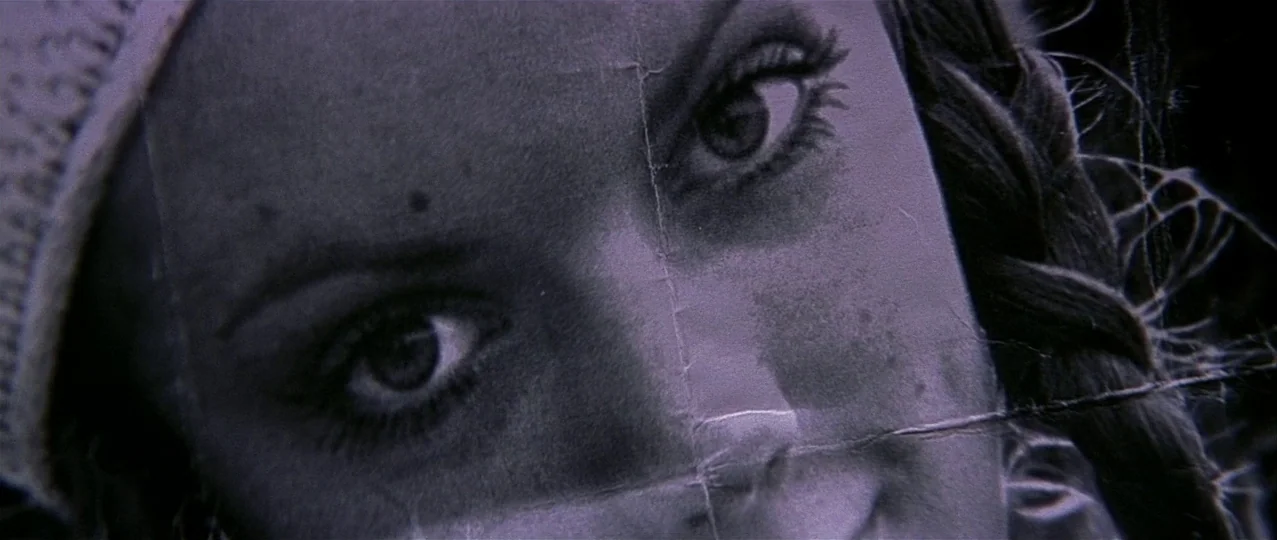 Scream 3 (2000) movie still: closeup — A close-up view shows a person's eyes printed on a piece of paper. Creases and folds are visible across the…