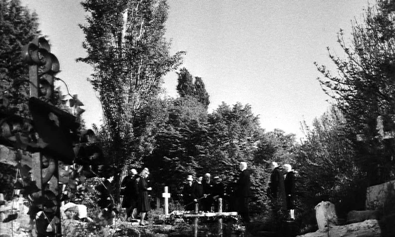 The Girl Who Knew Too Much (1963) movie still: wide — A rural cemetery features tall deciduous trees surrounding a cluster of grave markers. A small…