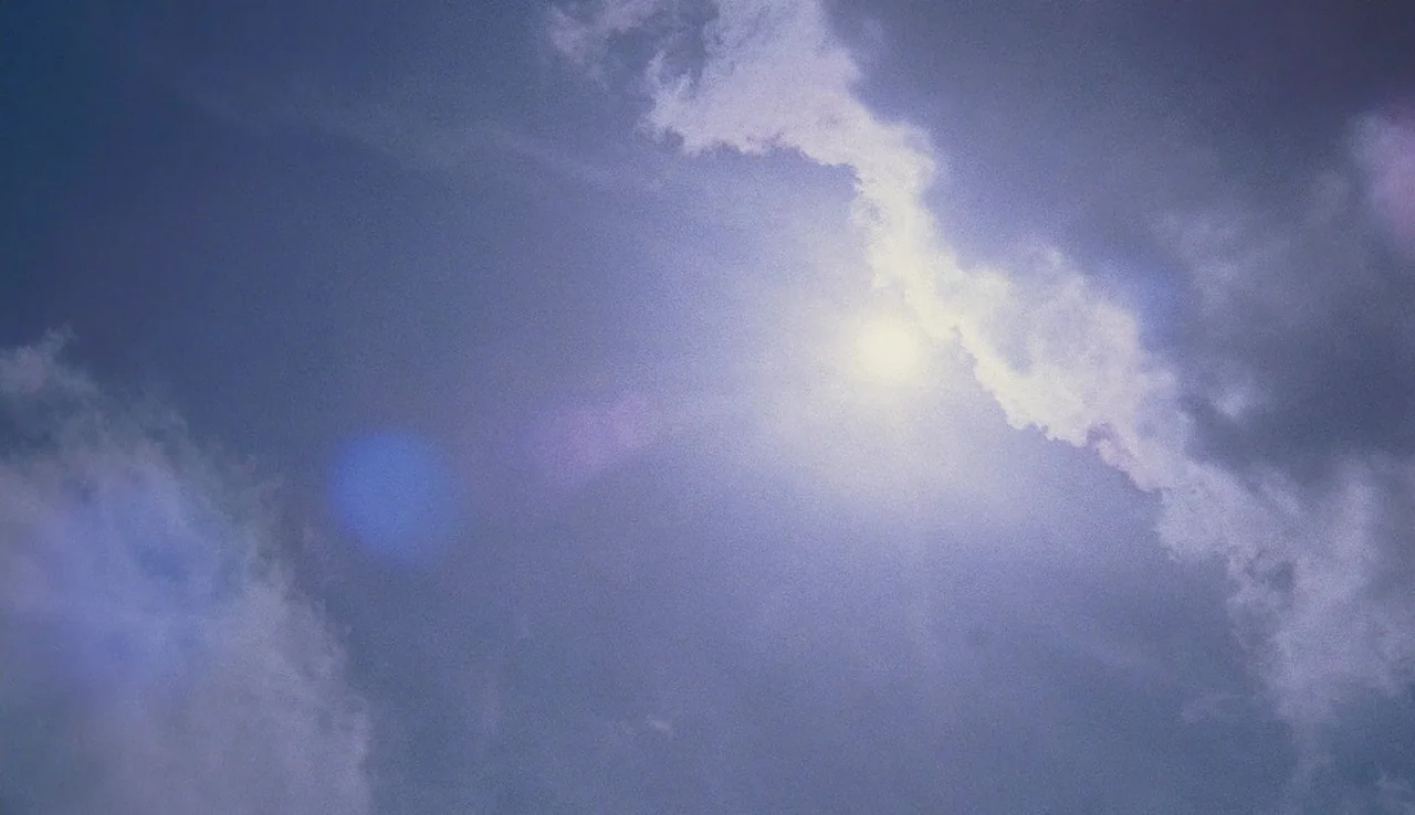 The Perks of Being A Wallflower (2012) movie still: establishing — A vast expanse of sky features layered blue clouds partially obscuring the bright…