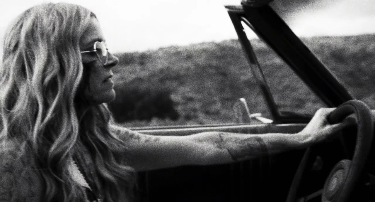3 From Hell (2019) movie still: medium — A woman drives a convertible vehicle through a rural or open landscape. The subject sits in the driver seat…