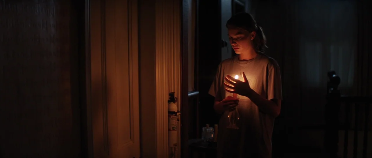 Z for Zachariah (2015) movie still: medium — A dim, narrow residential corridor with a fire extinguisher mounted on the paneled wall. A young woman…
