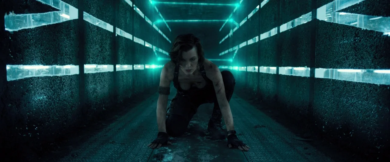 Resident Evil: The Final Chapter (2016) movie still: medium — A narrow metallic corridor with glowing teal neon light panels recessed into the…