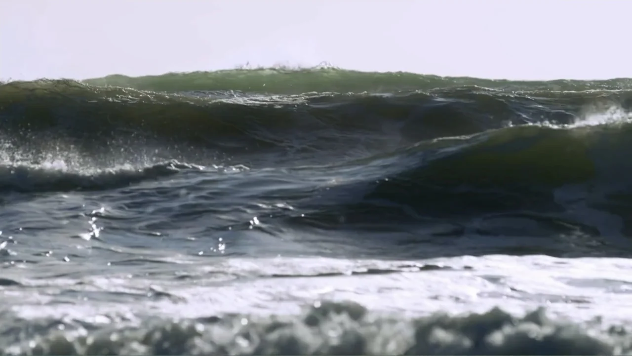Alien Sharks: Strange New Worlds (2023) movie still: wide — The frame shows a vast expanse of ocean with rolling waves under daylight. Dark green…