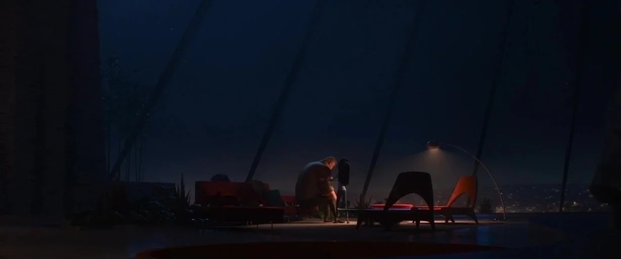 Incredibles 2 (2018) movie still: wide — A dark, modern living room features floor-to-ceiling glass walls looking out at a city. A man and a child…