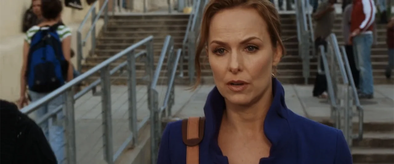 17 Again (2009) movie still: medium — A woman stands in front of a wide concrete staircase outdoors during the day. She addresses someone off-camera…