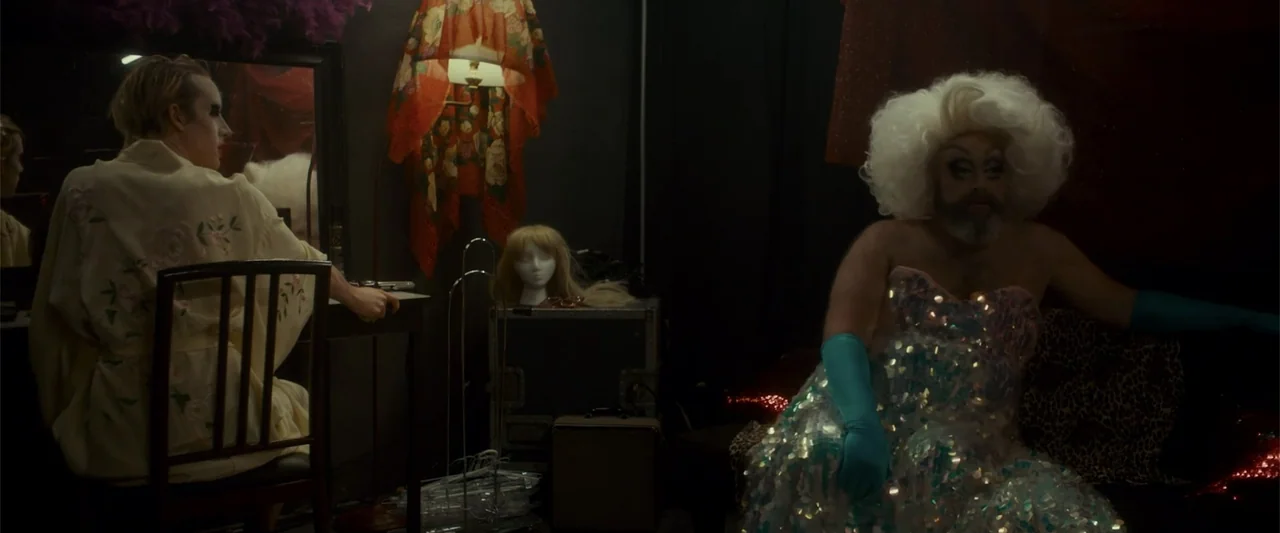 Jump, Darling (2022) movie still: medium — A dimly lit dressing room contains a vanity, mannequin head, and professional stage equipment. One…