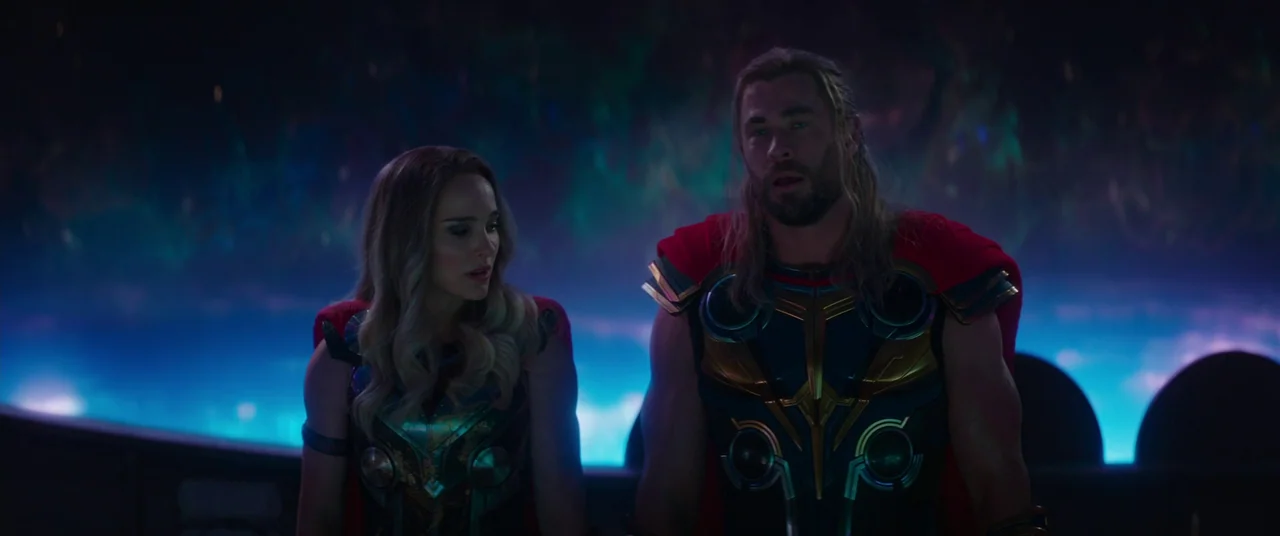 Thor: Love and Thunder (2022) movie still: medium — A dark, expansive cosmic interior is illuminated by pulsing neon blue light. The two armored…