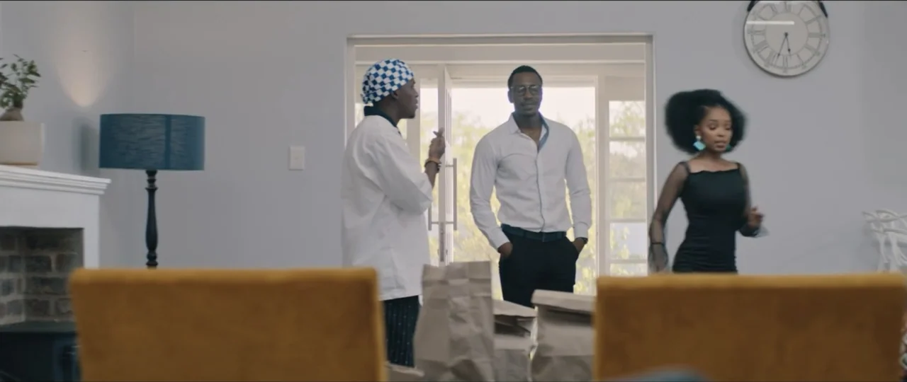 My Girlfriend's Father (2023) movie still: medium — A modern brightly lit interior features a doorway leading to an exterior view. Three individuals…