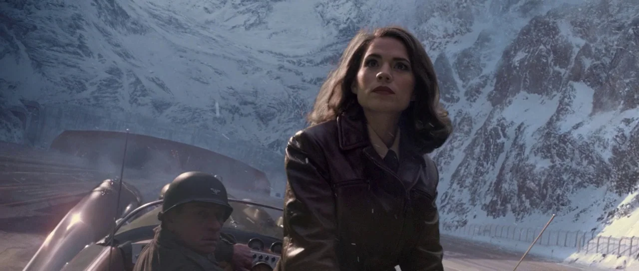 Captain America: The First Avenger (2011) movie still: medium — A snowy mountain landscape serves as a backdrop to an open military vehicle. A woman…