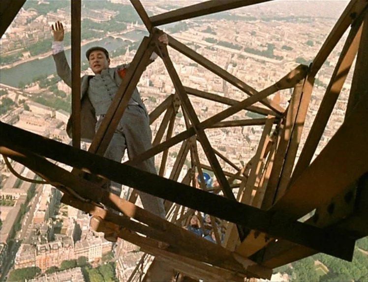 Zazie Dans Le Métro (1960) movie still: fullbody — A high-altitude perspective of a man climbing the iron girders of a tall structure. The city of…