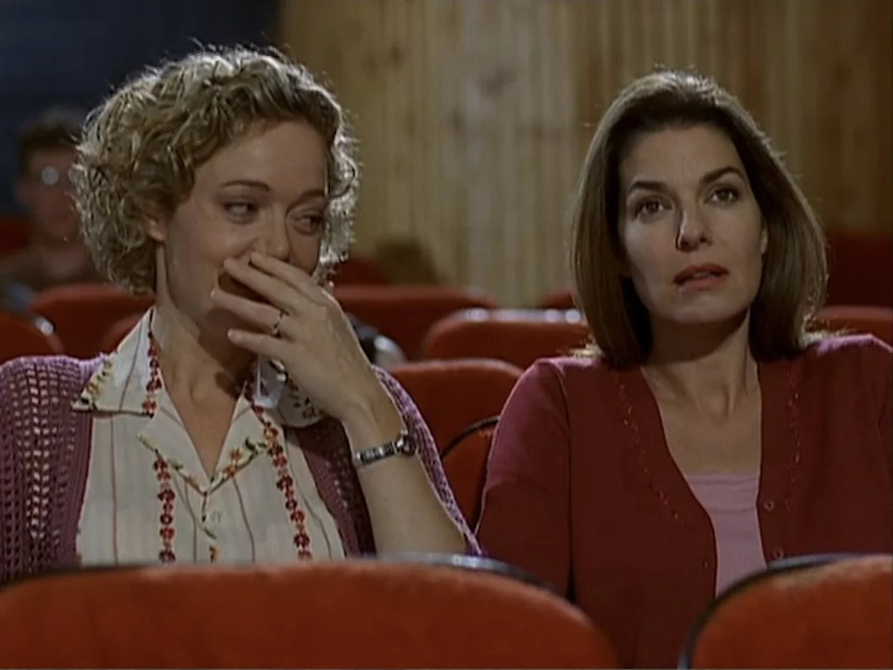 Catch a Falling Star (2000) movie still: medium — Two women sit side by side in red velvet seats inside a dark movie theater. The woman on the left…