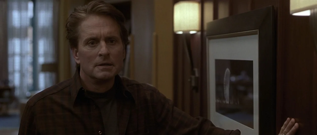 Don't Say a Word (2001) movie still: medium — A dimly lit room with dark wood paneling and wall-mounted lamp fixtures. A middle-aged man stands near…