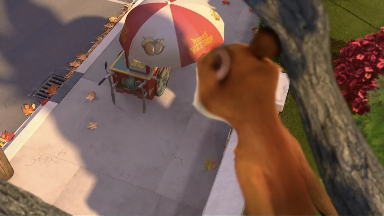 The Nut Job (2014) movie still: wide — A sidewalk paved with stone tiles features a colorful wheeled cart with an umbrella. A brown squirrel perched…