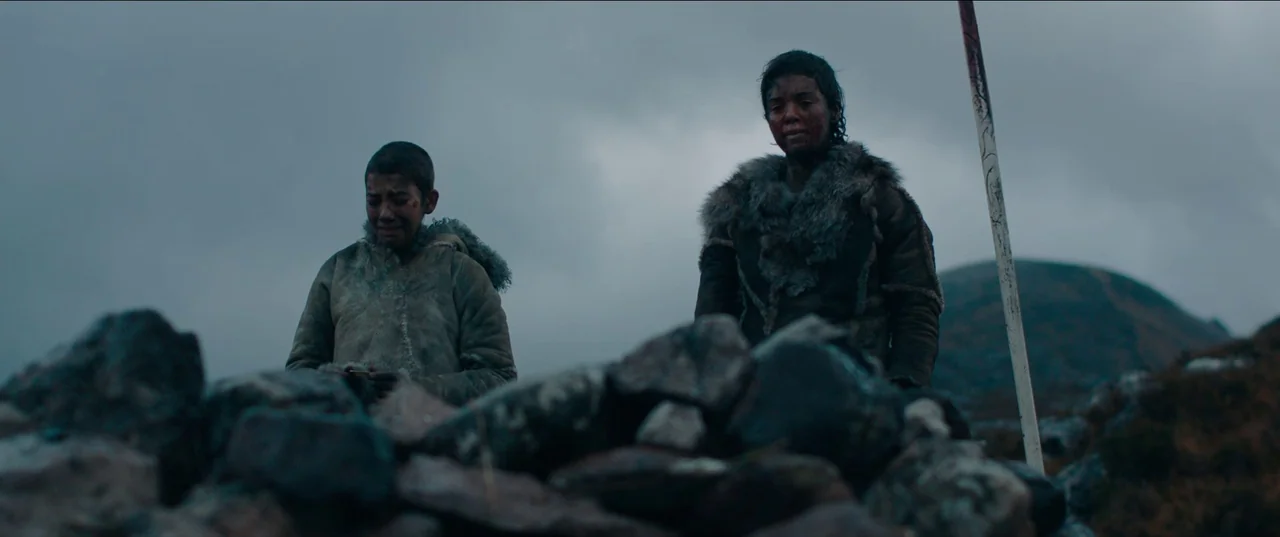 Out of Darkness (2022) movie still: medium — A desolate high-altitude mountain landscape under heavy, grey overcast storm clouds. Two young people…