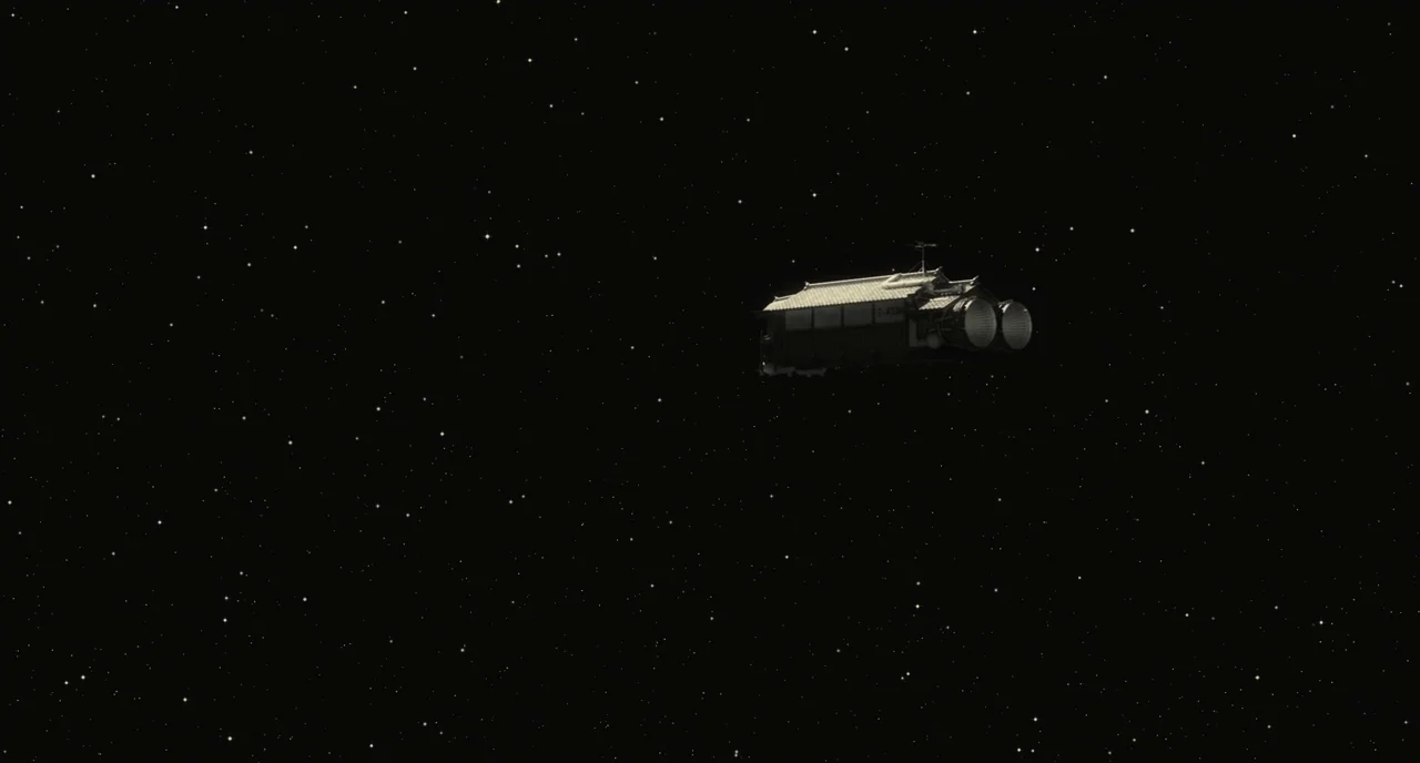 The Whispering Star (2015) movie still: wide — A dark, star-filled void of space serves as the backdrop for a drifting craft. The vessel resembles a…