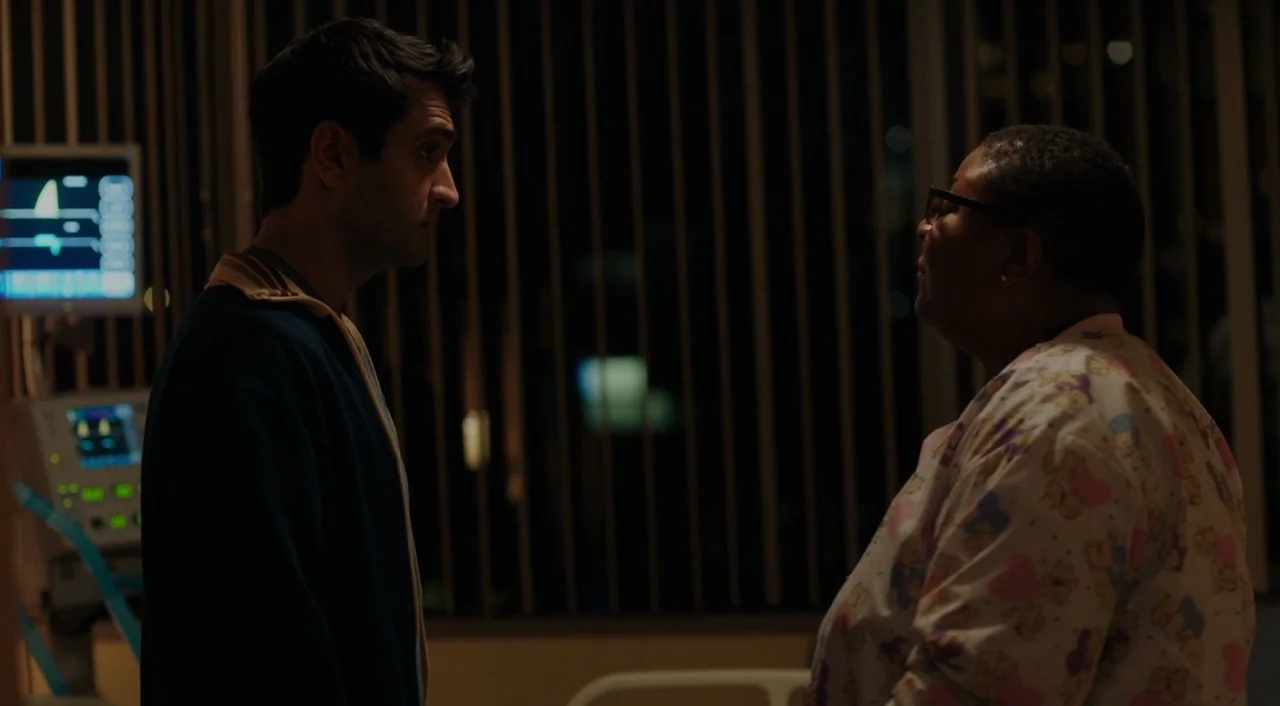 The Big Sick (2017) movie still: medium — Two individuals stand in a dimly lit medical space at night near monitors. The man faces the nurse as they…