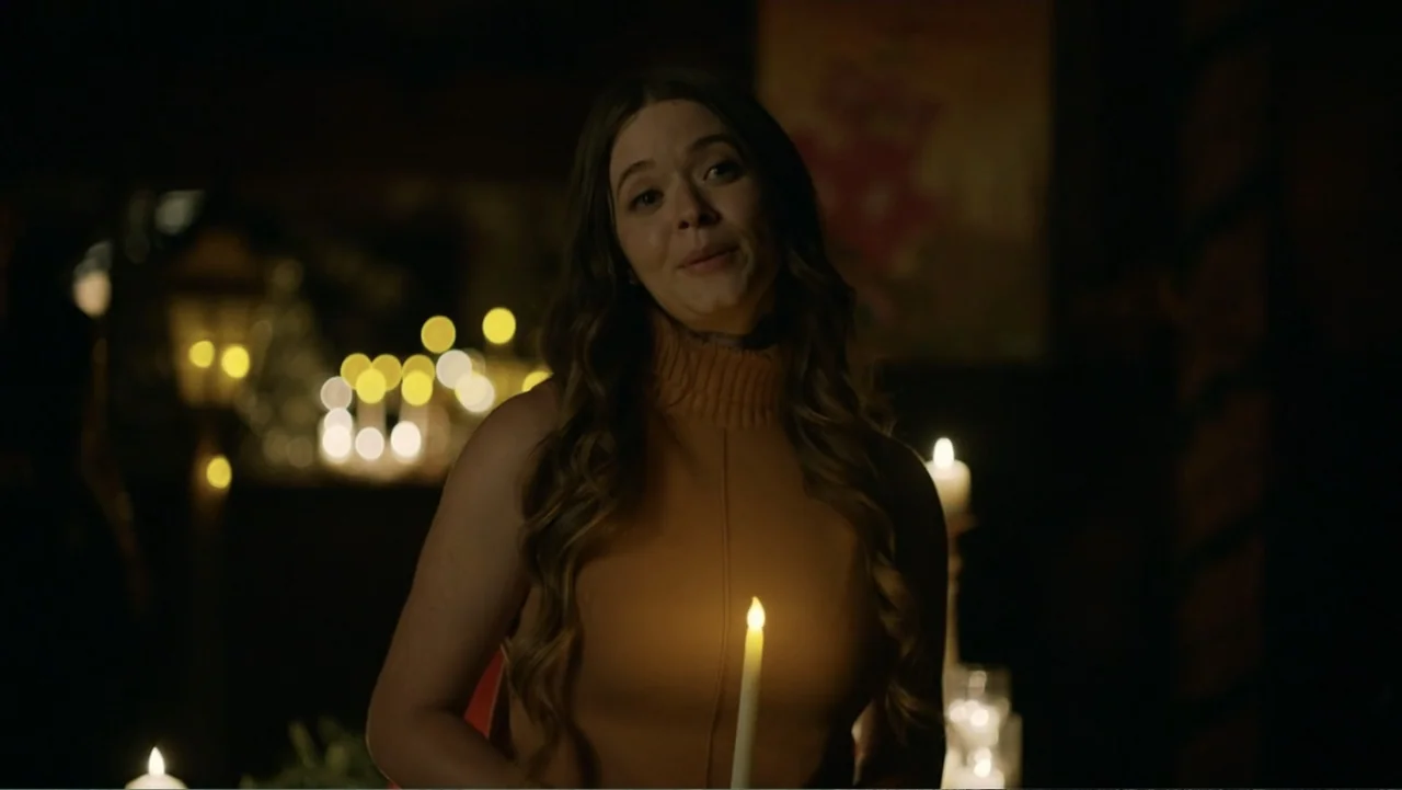 A Carpenter Christmas Romance (2024) movie still: medium — A dimly lit interior space filled with multiple candles providing the primary light…