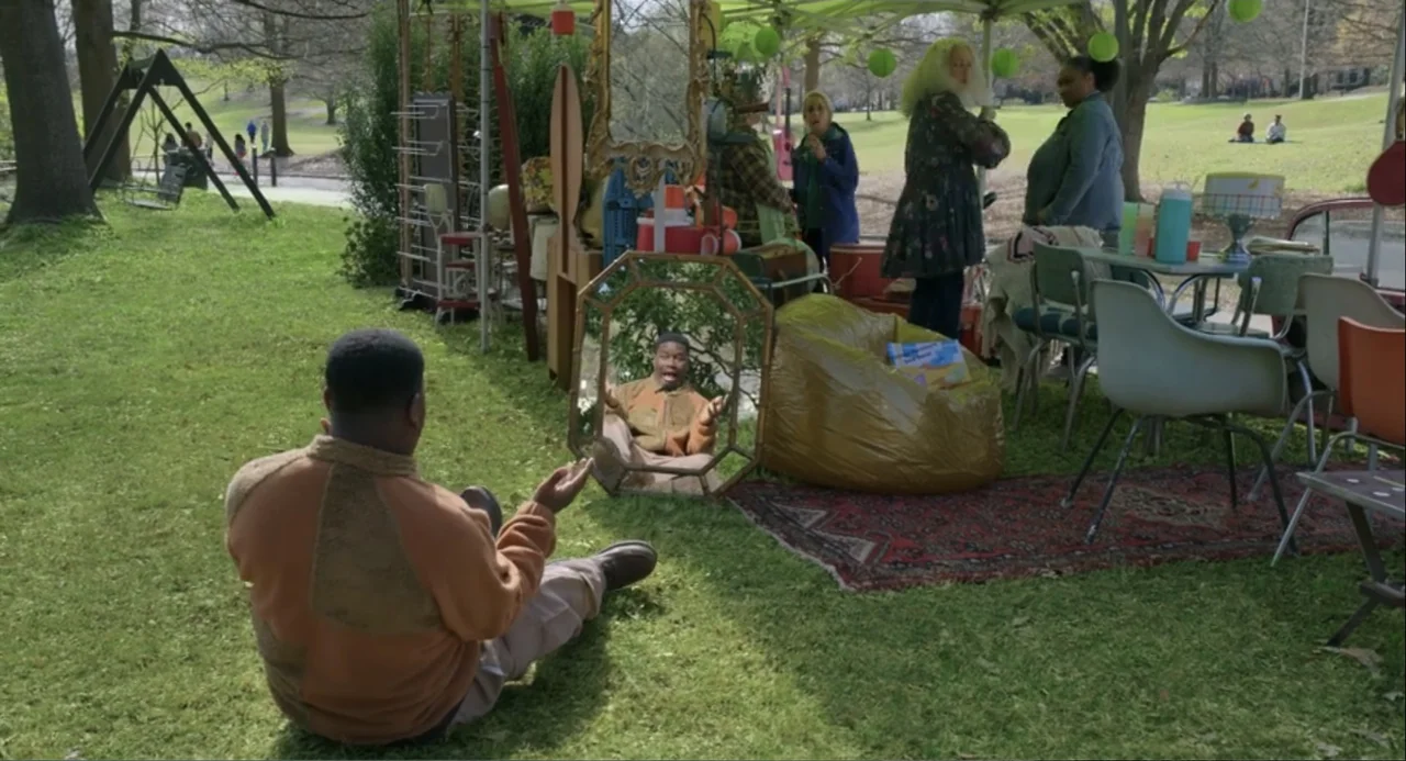 Harold and the Purple Crayon (2024) movie still: medium — An outdoor market stall displays various vintage mirrors and furniture on a grassy field.…