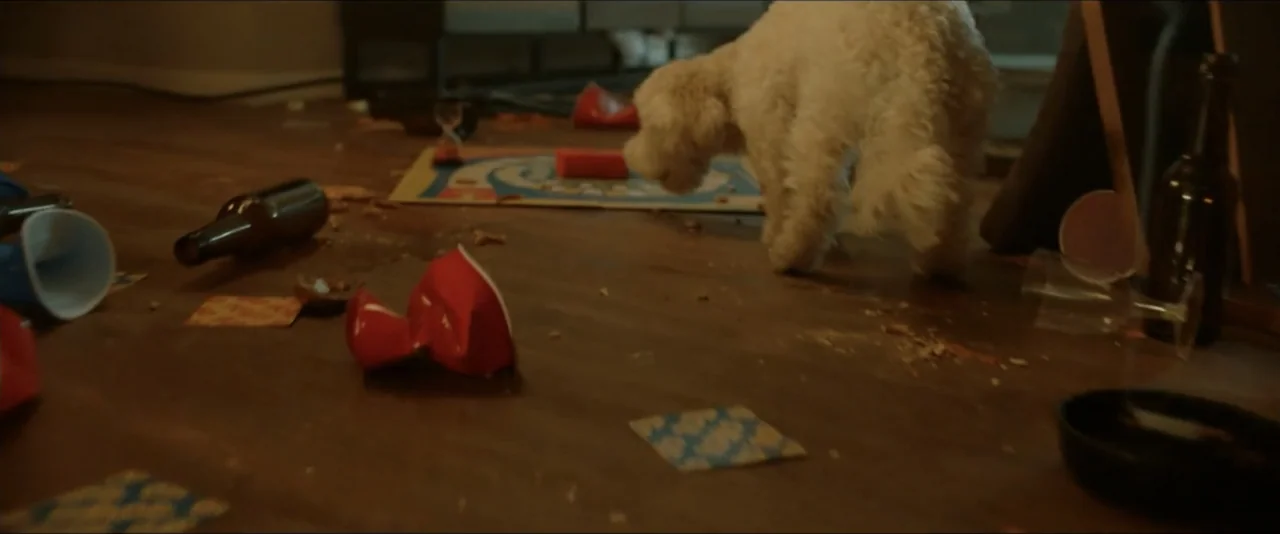 Gatlopp: Hell of a Game (2022) movie still: medium — A messy floor covered in discarded red plastic cups, beer bottles, and board games. A small…