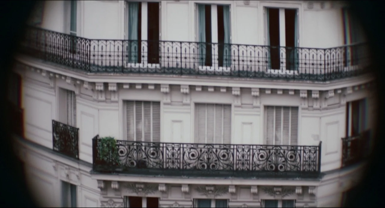 The Night Eats the World (2018) movie still: establishing — A Parisian-style residential building facade features multiple floors with wrought iron…
