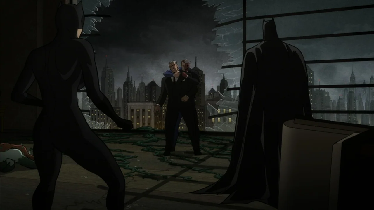 Batman: The Long Halloween, Part Two (2021) movie still: wide — A dark office overlooking a city at night with shattered glass windows. Batman and…