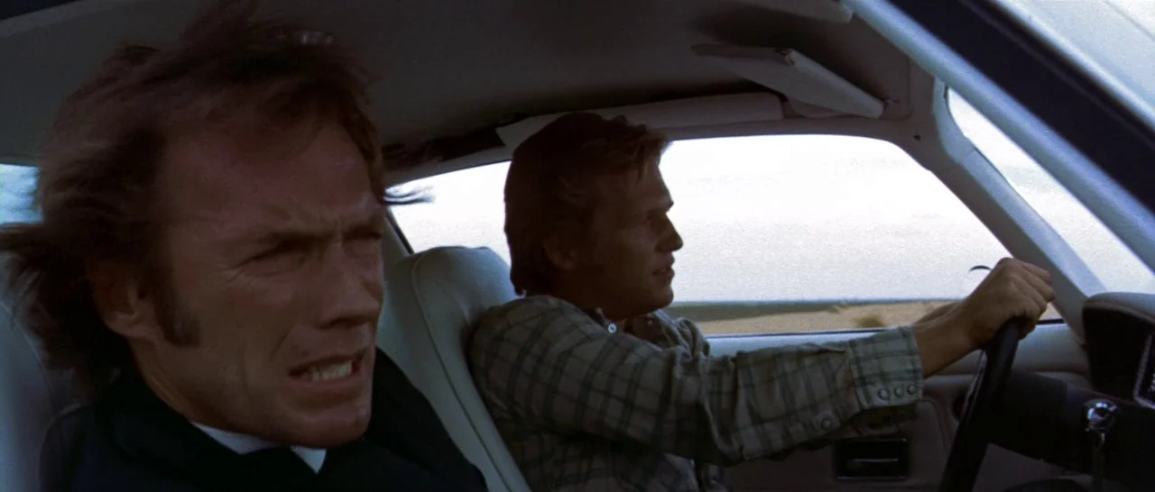 Thunderbolt & Lightfoot (1974) movie still: medium — A 1970s sedan interior provides a compact space for two men during travel. The passenger…