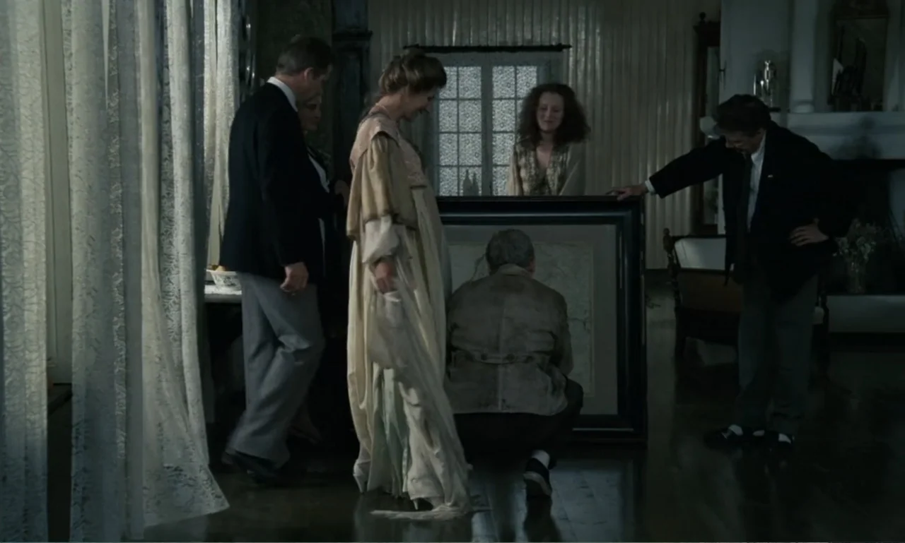 The Sacrifice (2015) movie still: medium — A refined interior space features lace curtains and period-style furnishings. Five adults stand around a…